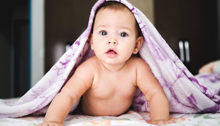 un bébé avec une couverture sur la tête